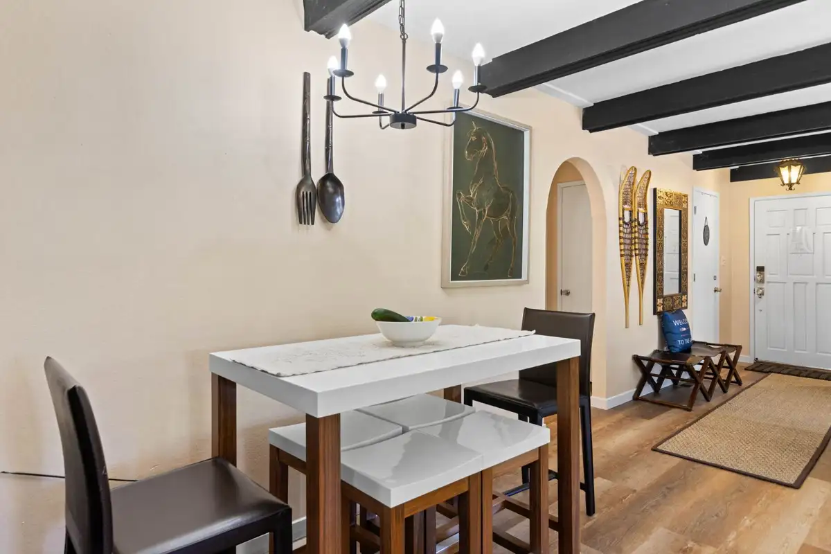 Small dining table under a chandelier near the front door, Cortina Chalet