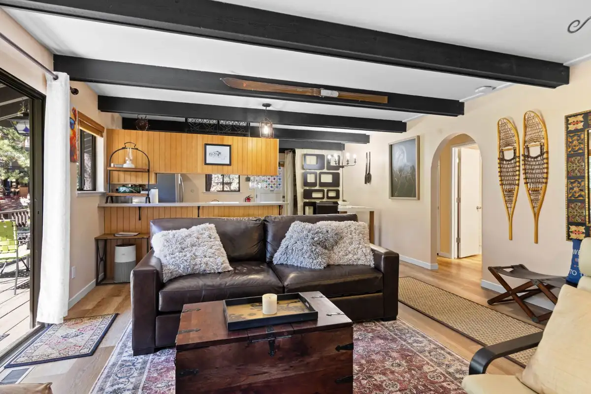Living room with a leather sofa and kitchen beyond, Cortina Chalet