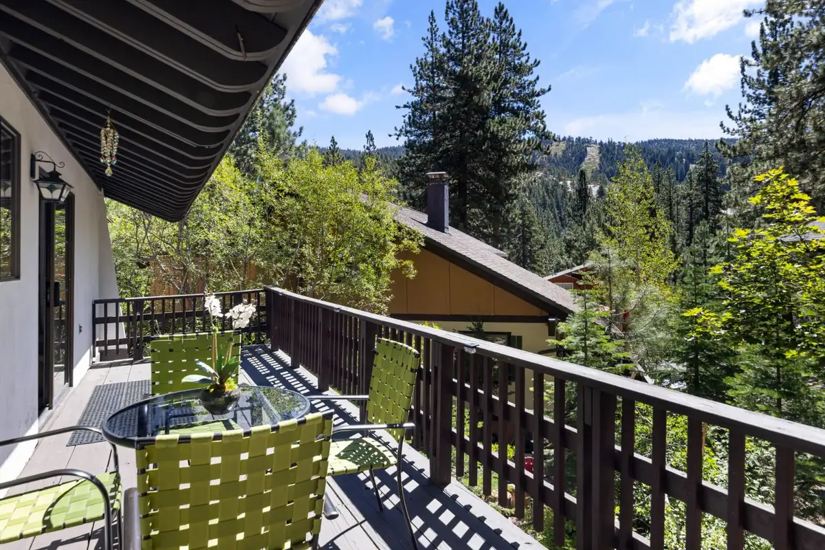 Balcony with green chairs and glass table overlooking trees, Cortina Chalet