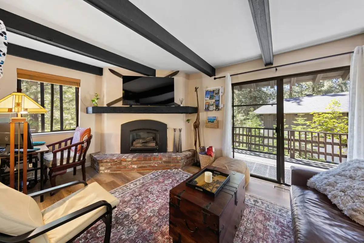 Living room with a fireplace, wall TV and sliding doors to a deck, Cortina Chalet