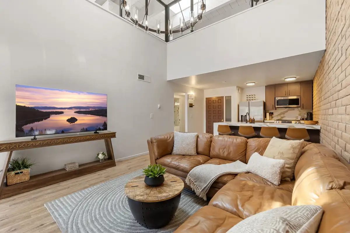 Open-concept living area with marble kitchen island, stone fireplace, and vaulted ceilings, Treetop on Country Club