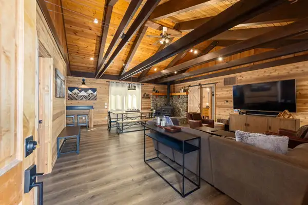 Open living area with exposed beams and wood-paneled walls, Updated West Shore Cabin 1 mile to Chambers Beach