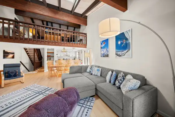Living room with gray sectional and loft above, Skiway Suite