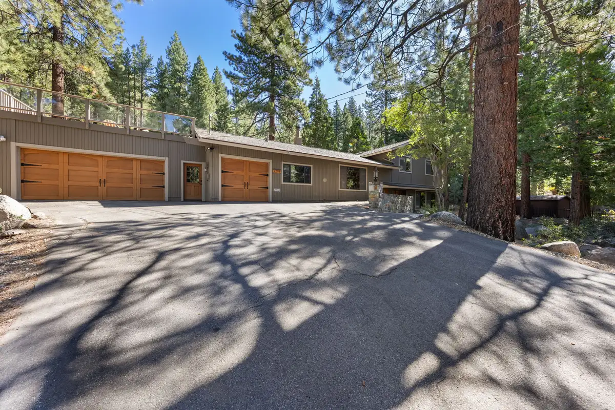 Wood-sided home with garage doors and a wide paved driveway, Tranquil Stay