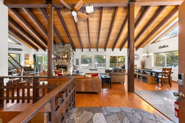 Open great room with stone fireplace and wood ceiling, Sierra Woodlands Getaway