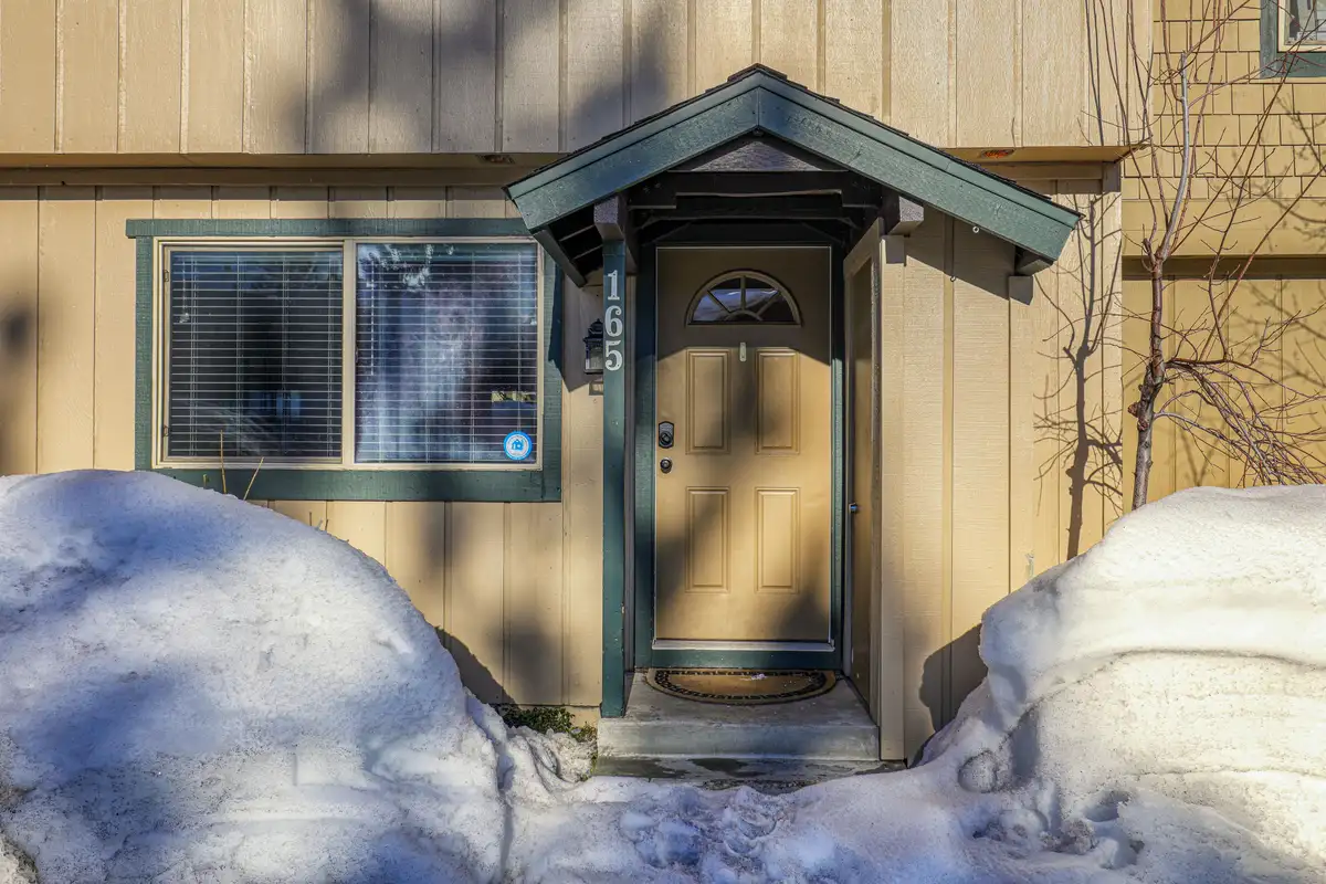 Front door with a small gabled porch in snow, Trailside Tahoe Townhouse