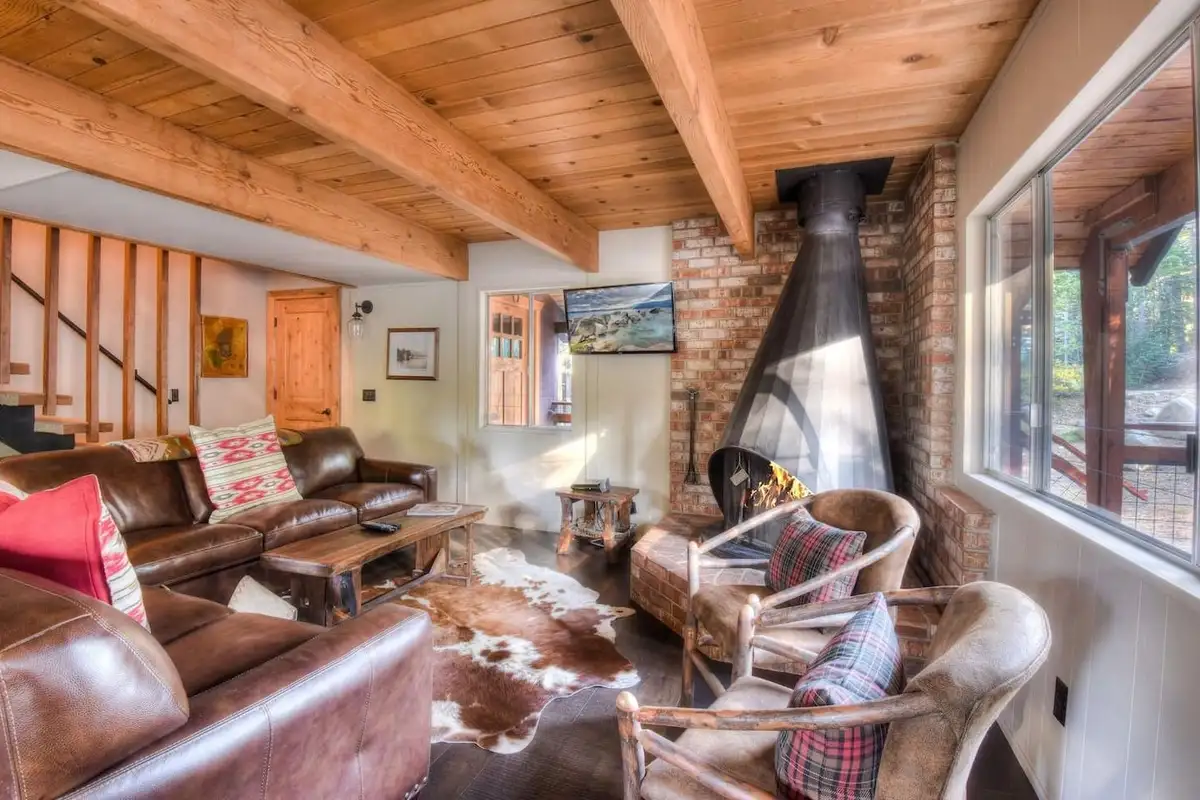 Living room with a freestanding fireplace and leather sofas, Enchanting Chamberlands Cabin