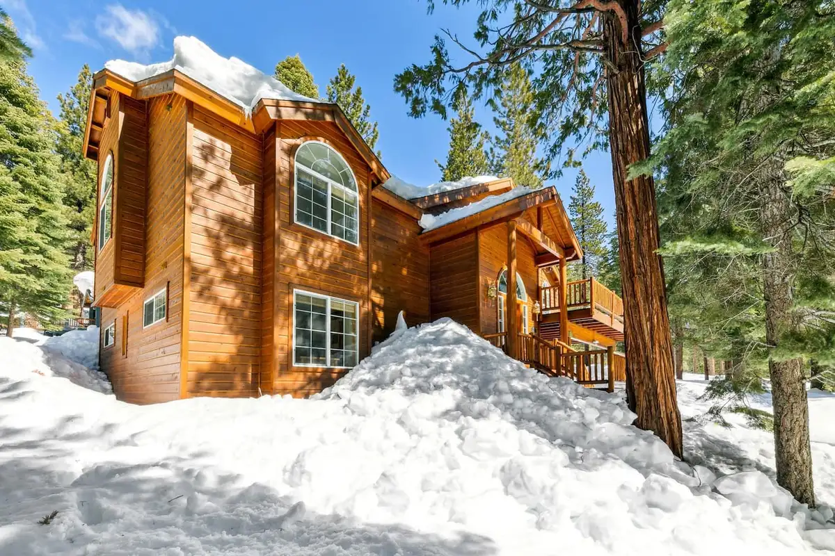 Large wood-sided home with arched windows in snow, Hastings Hideaway Cabin