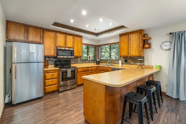 Kitchen with wood cabinets, breakfast bar and black stools, Grand Regency Retreat