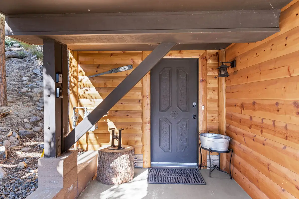 Covered front entry with dark door and wood siding, Livin' on the Edge
