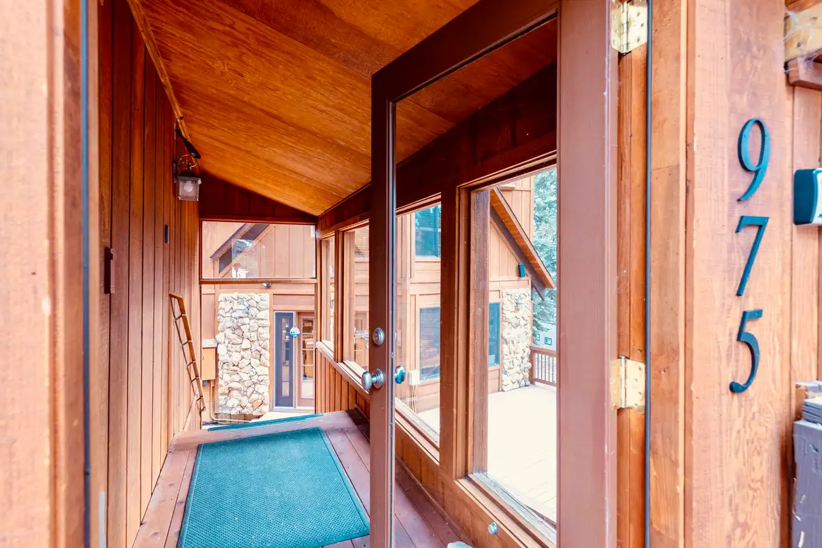 Covered entry walkway with wood framed doors, Sunlit Incline Retreat