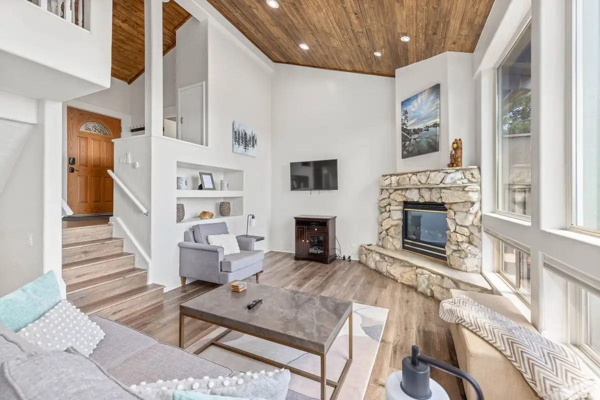 Living room with stone fireplace and large windows, Lakeview Haven in Incline Village