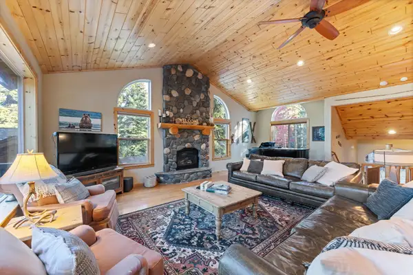 Living room with stone fireplace and leather sofas, Lakeview Grandeur