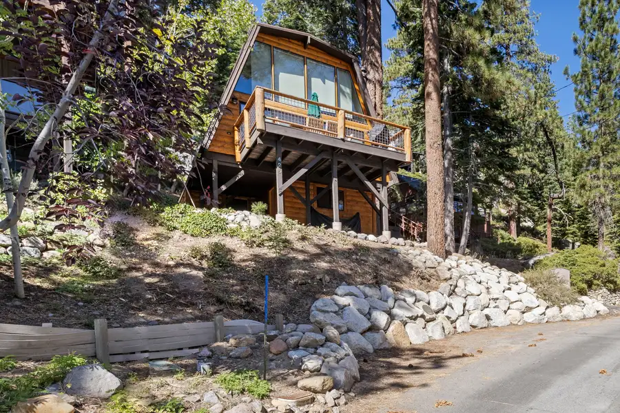 A-frame cabin with a deck on a wooded hillside, Livin' on the Edge