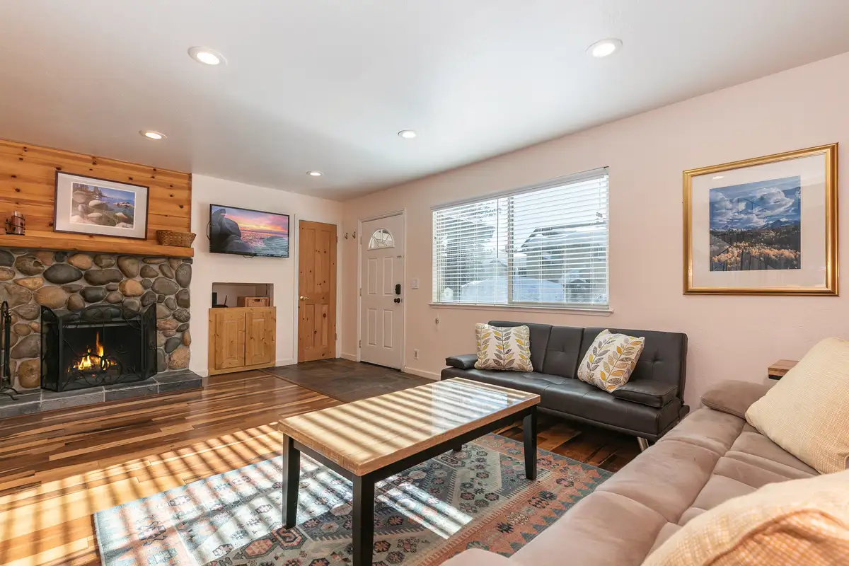 Living room with stone fireplace and leather sofas, Trailside Tahoe Townhouse