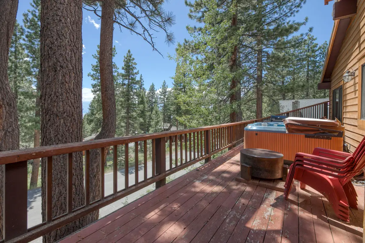 Deck with a hot tub and red chairs among pines, Lunar Lakeview Haven