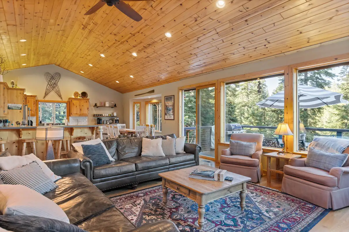 Living room with wood ceiling and kitchen behind, Lakeview Grandeur