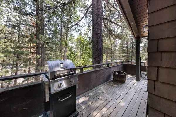 Wood deck with a grill among tall pines, Incline Tranquil Loft