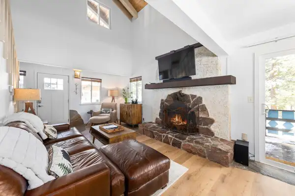 Living room with leather sectional and stone fireplace, Mountaintop Retreat