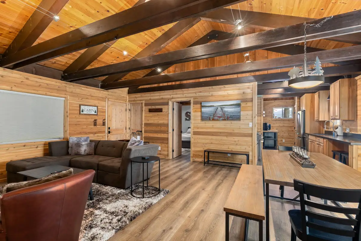 Open living and dining area under exposed wood beams, Updated West Shore Cabin 1 mile to Chambers Beach