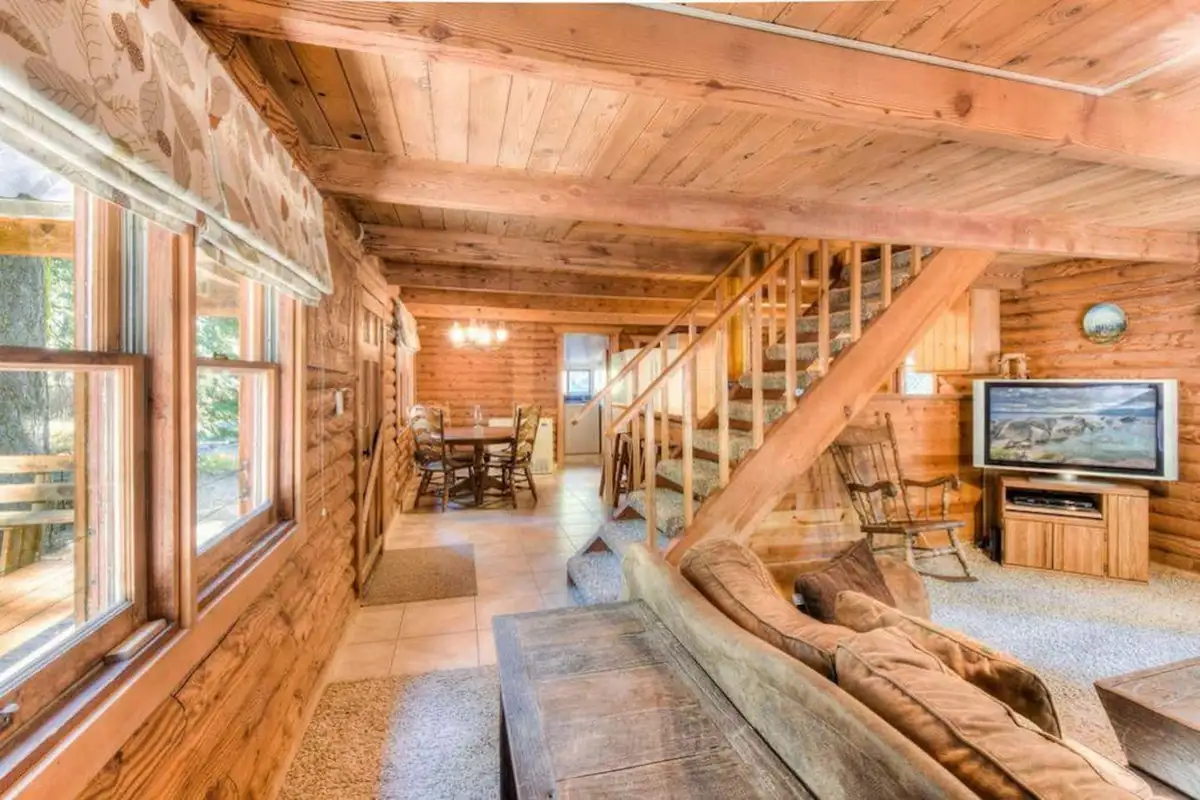 Log cabin living room with a staircase and TV cabinet, Enchanted Woods Cabin