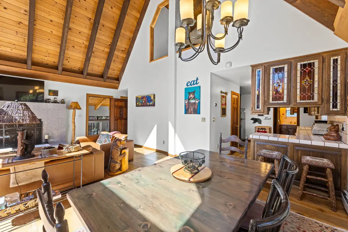 Dining table under a vaulted wood ceiling with kitchen bar, Rustic Ridge Retreat
