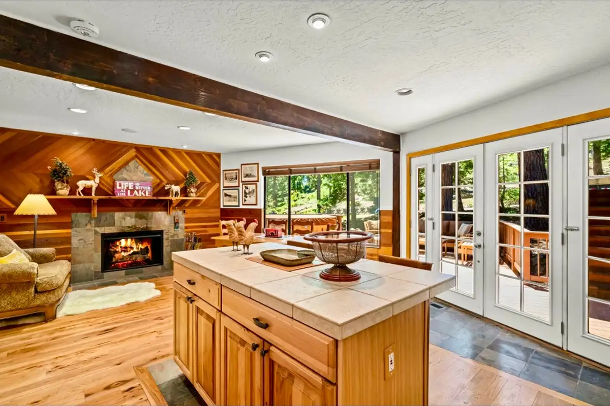 Kitchen island facing a fireplace and French doors, Sunlit Incline Retreat