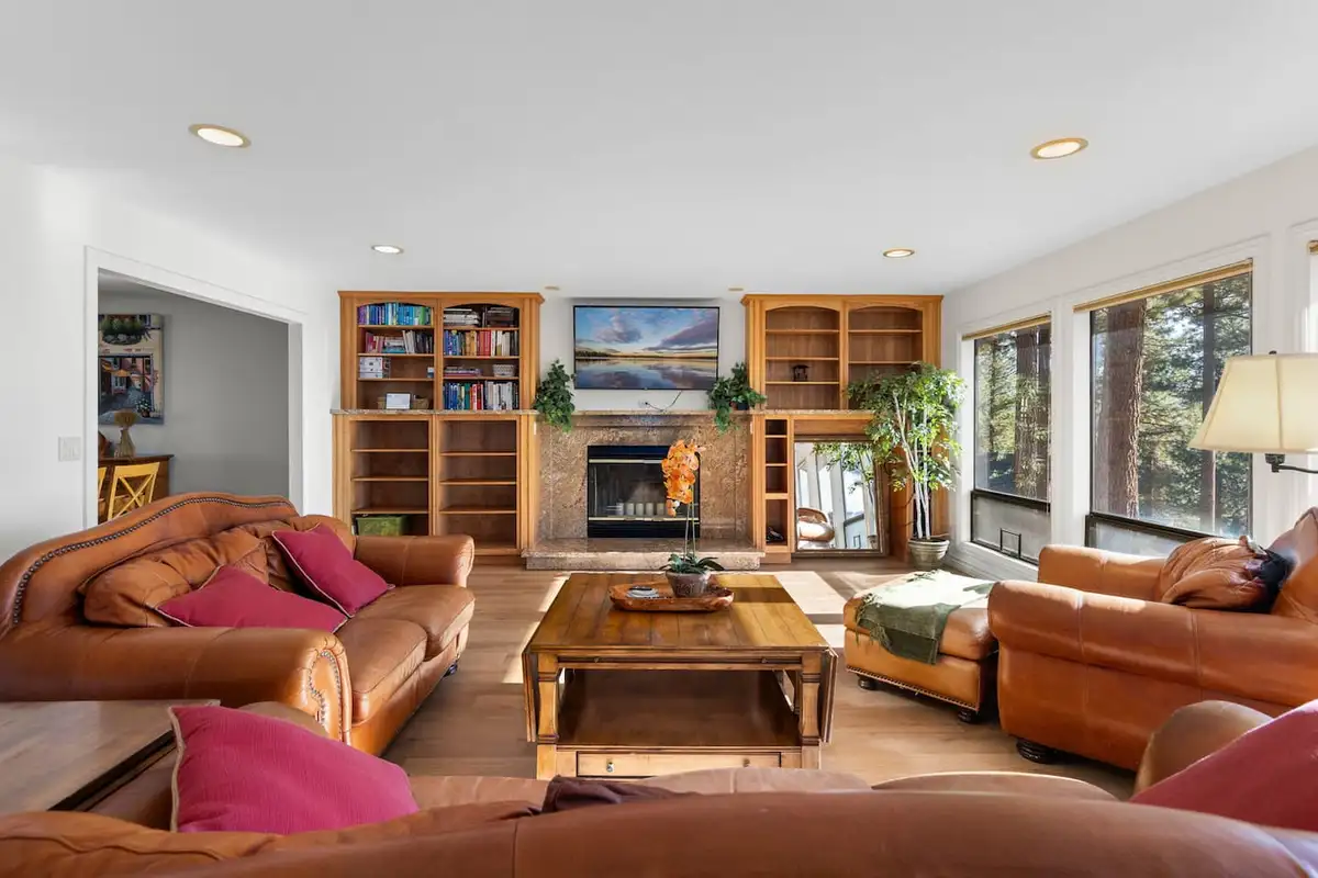 Living room with leather sofas, fireplace and built-in bookshelves, Tranquil Alpine Bliss