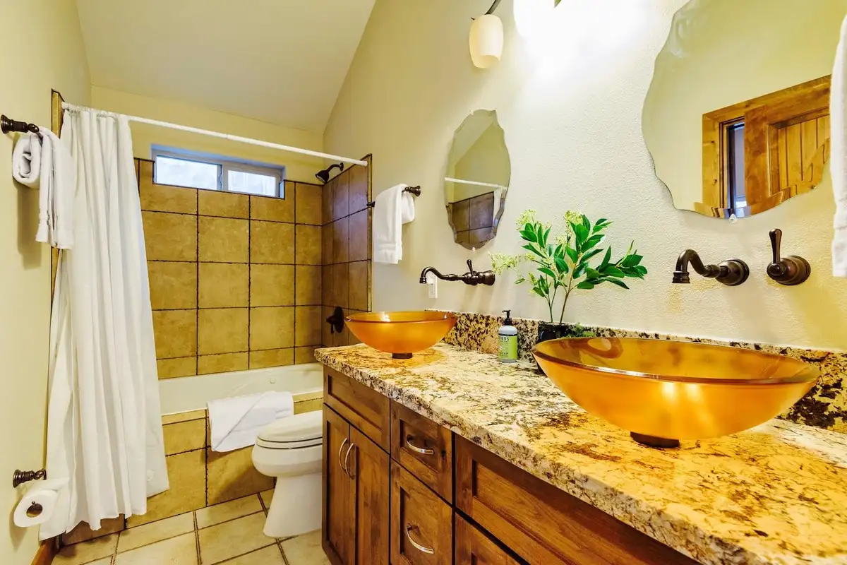 Bathroom with granite double vanity and amber vessel sinks, Trout and About