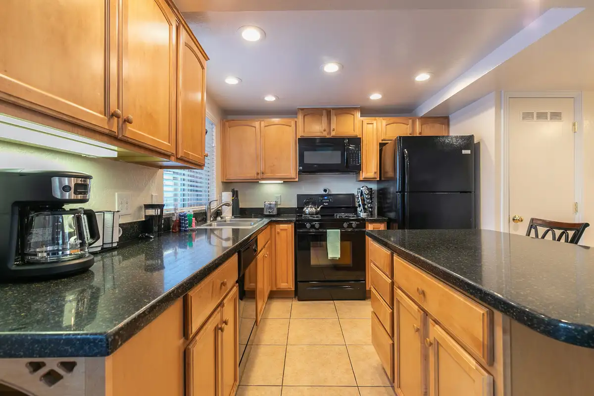 Kitchen with wood cabinets and dark granite counters, Trailside Tahoe Townhouse