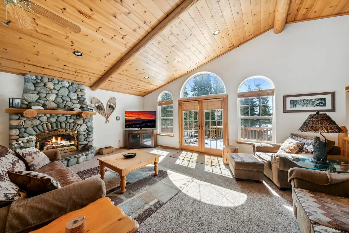 Living room with river rock fireplace and arched windows, Hastings Hideaway Cabin