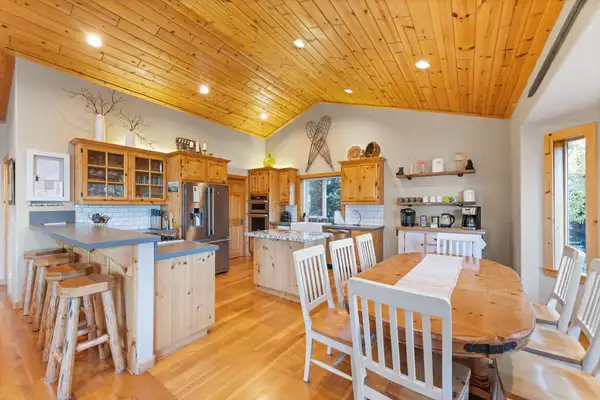 Dining table with kitchen and breakfast bar behind, Lakeview Grandeur