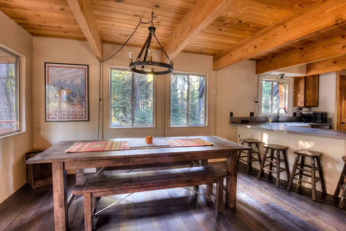 Dining table with benches beside a breakfast bar, Enchanting Chamberlands Cabin