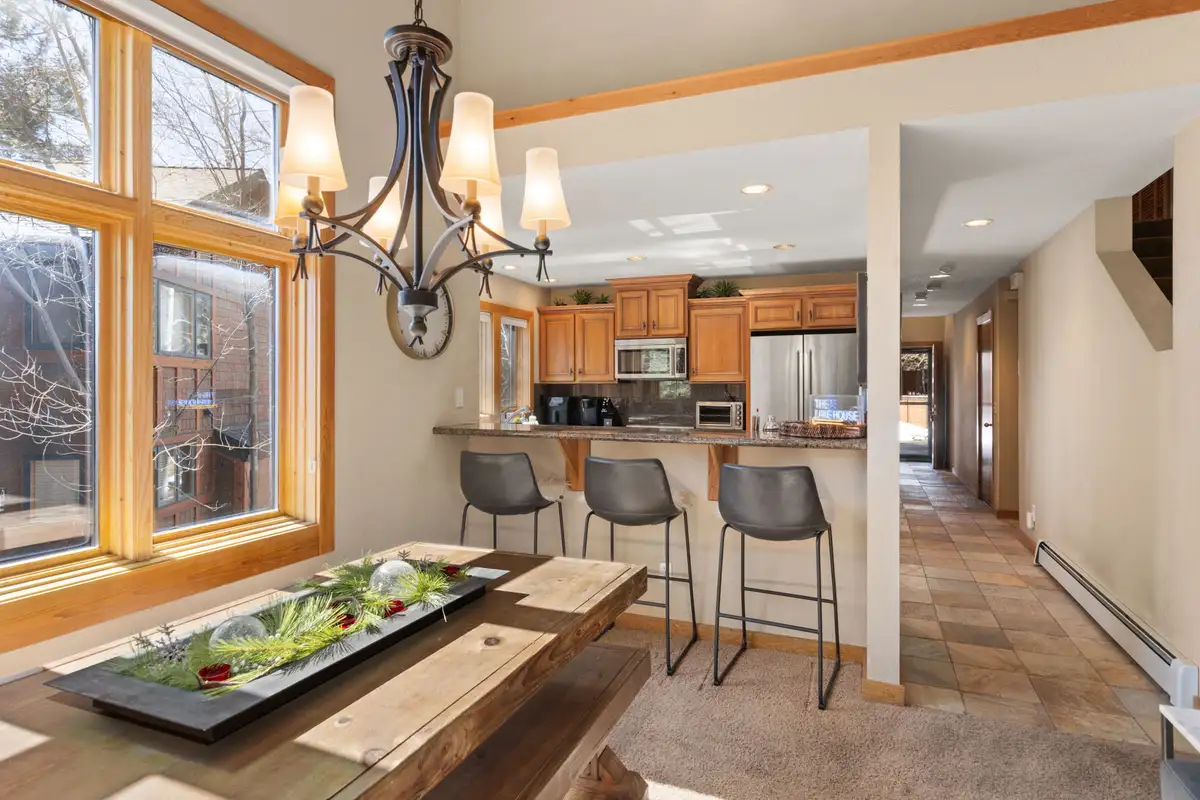 Wood dining table with bar stools and kitchen behind, Elevated Tahoe Escape