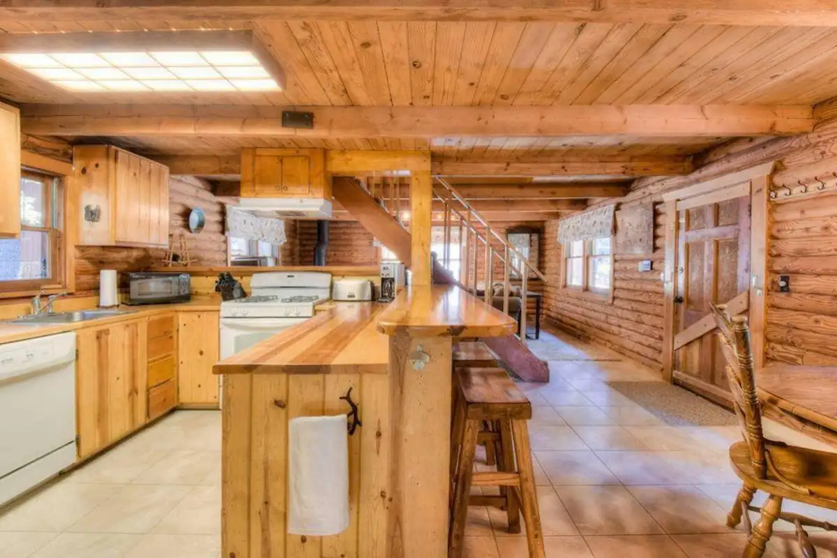 Log cabin kitchen with pine cabinets and breakfast bar, Enchanted Woods Cabin