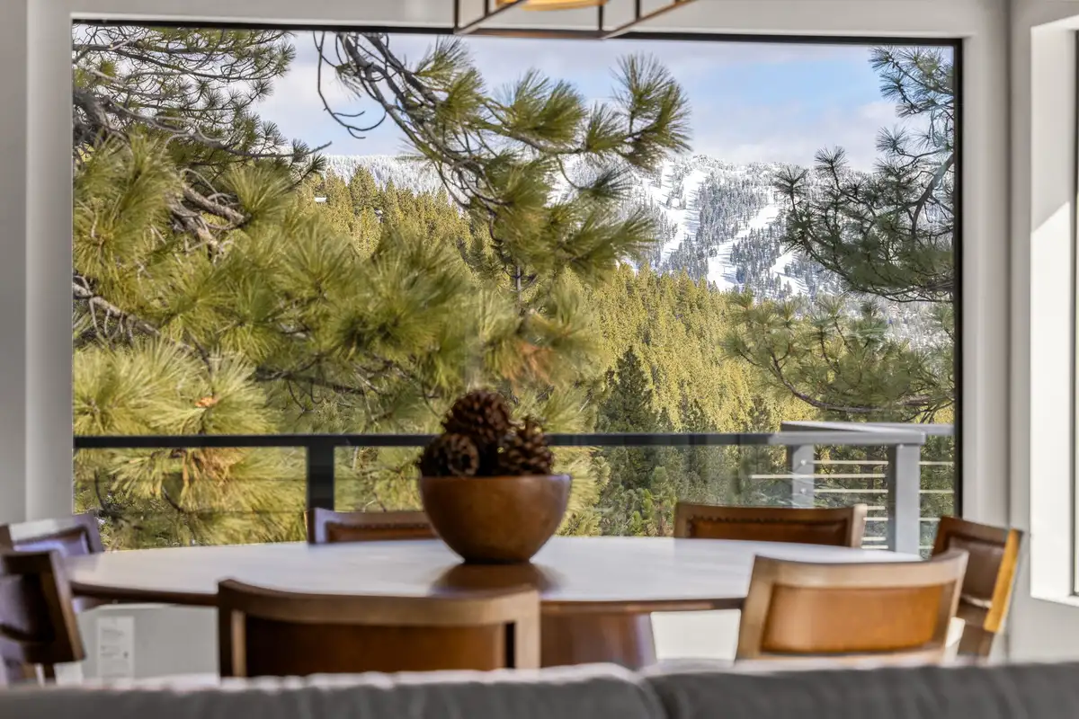 Dining table by a large window overlooking forested slopes, Incline Lakehouse Lookout