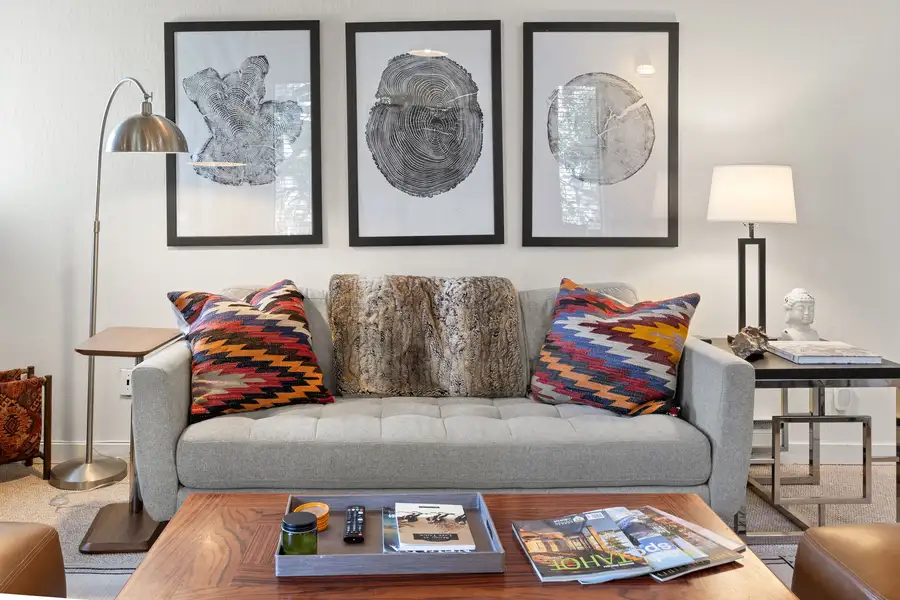 Living area with a gray sofa and framed tree-ring art, Serenity Bungalow