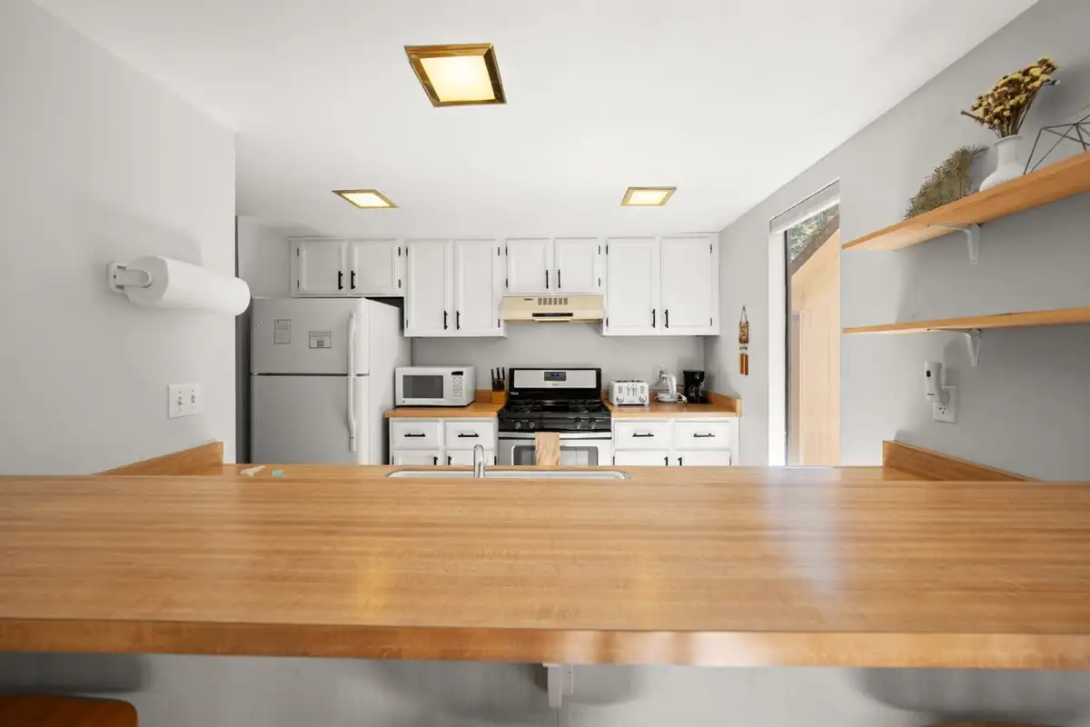 Kitchen with white cabinets and butcher-block counter, Skiway Suite