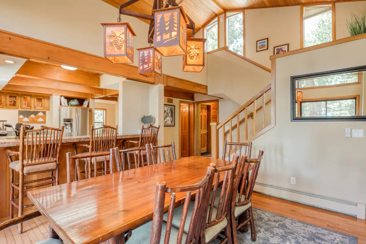 Dining area with a long wood table and lantern lights, Lunar Lakeview Haven