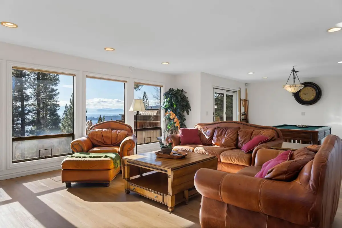 Living room with a leather sectional and large windows, Tranquil Alpine Bliss