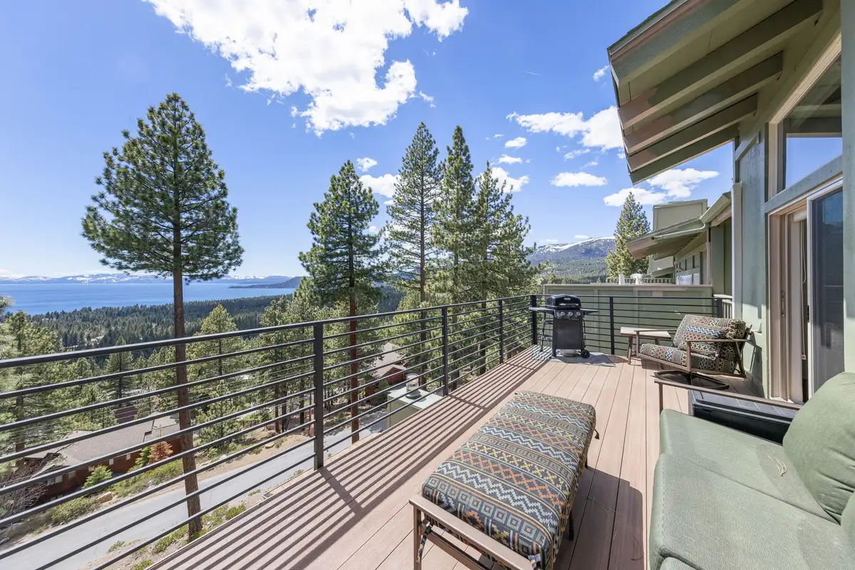 Deck with railing and Lake Tahoe visible beyond the trees, Lakeview Haven in Incline Village