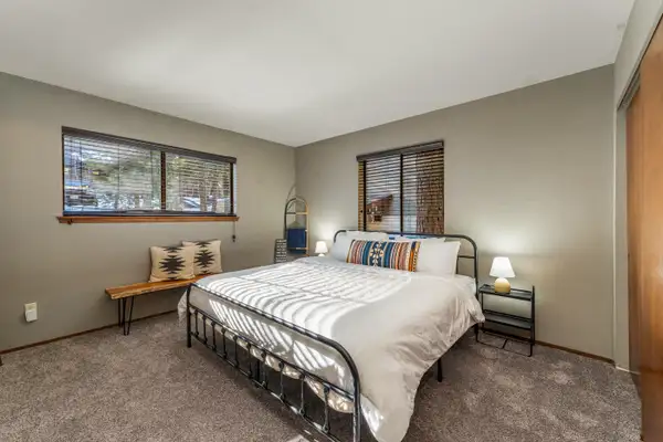 Bedroom with a metal-frame bed and bench, Grand Regency Retreat