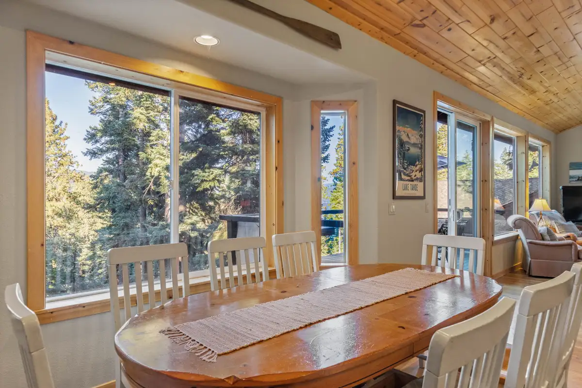 Oval dining table beside large windows to the trees, Lakeview Grandeur