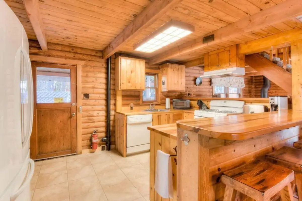 Pine kitchen with a breakfast bar and back door, Enchanted Woods Cabin