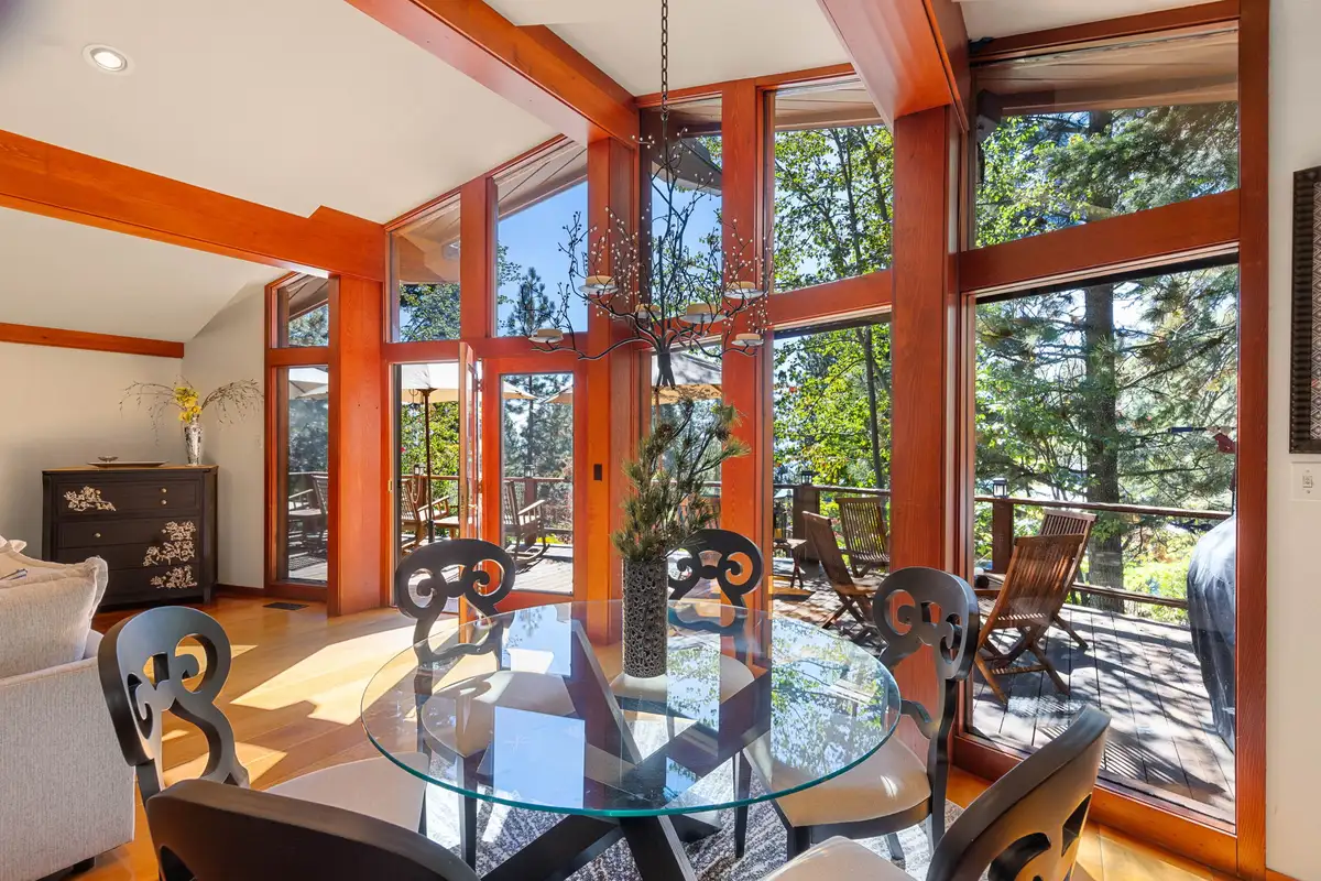Glass dining table surrounded by floor-to-ceiling windows, Incline Lakeside Haven