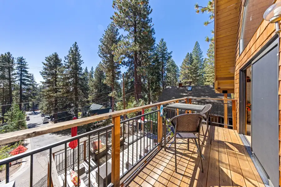 Deck with railing and chairs among pine trees, Rustic Ridge Retreat