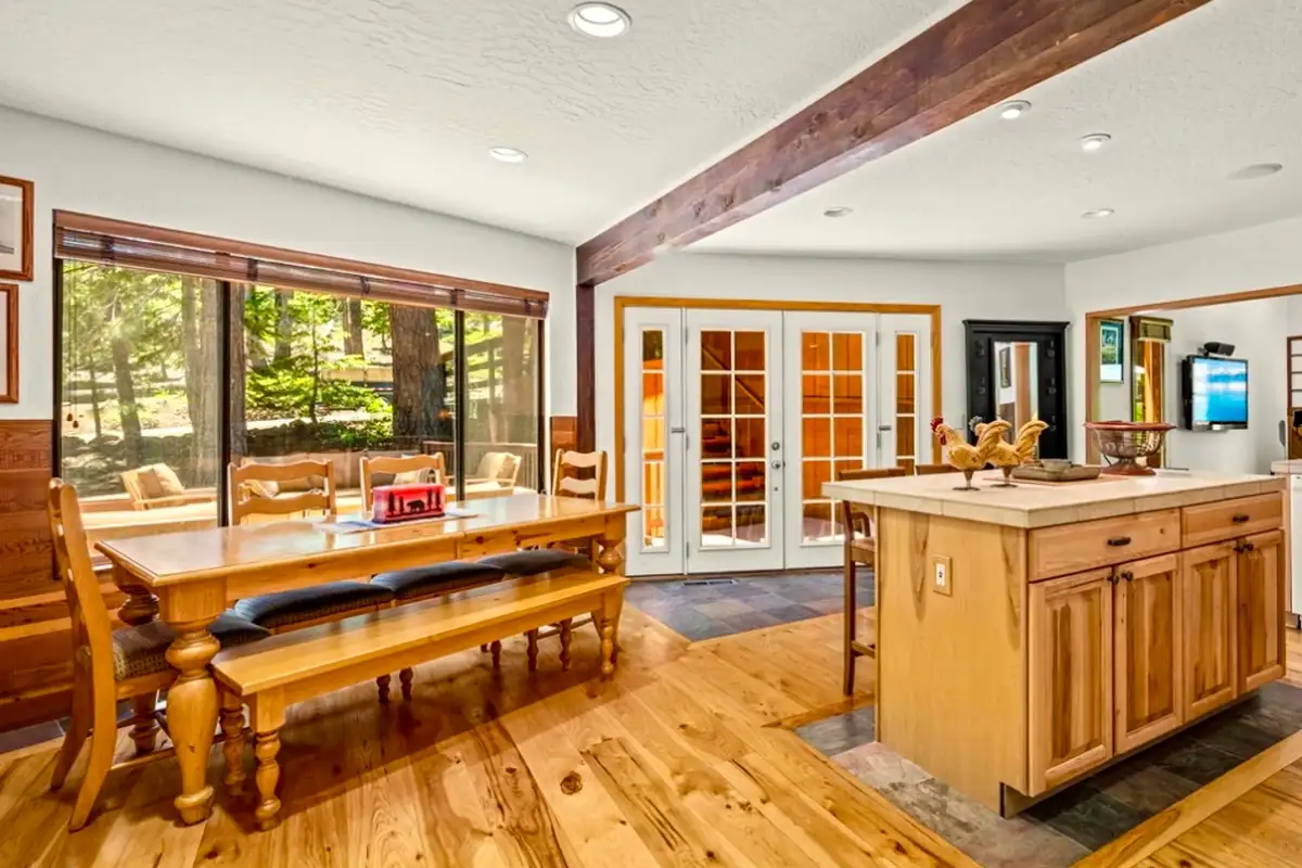 Dining table with bench beside a kitchen island, Sunlit Incline Retreat