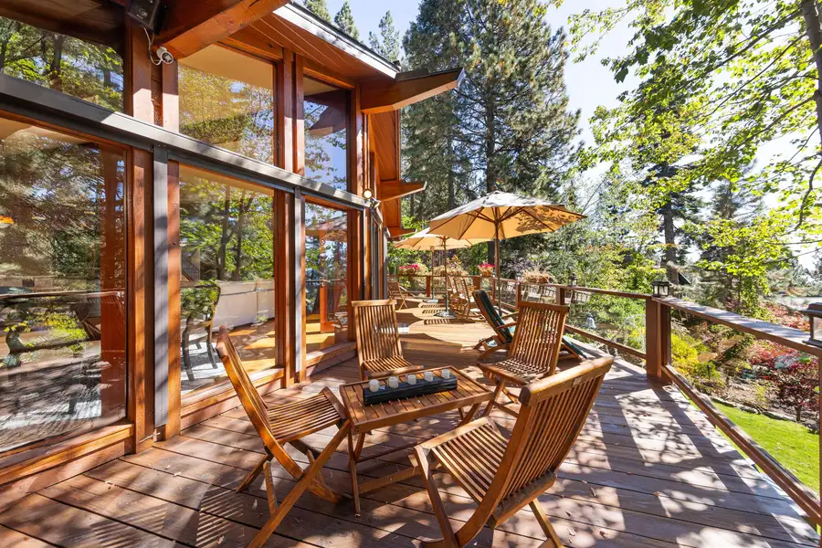 Deck with wood chairs and umbrellas among trees, Incline Lakeside Haven