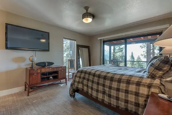 Bedroom with plaid bedding, wall TV and sliding doors to a deck, Skylake Serenity Retreat