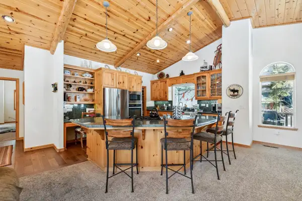 Kitchen with a wood island and bar stools under a wood ceiling, Hastings Hideaway Cabin